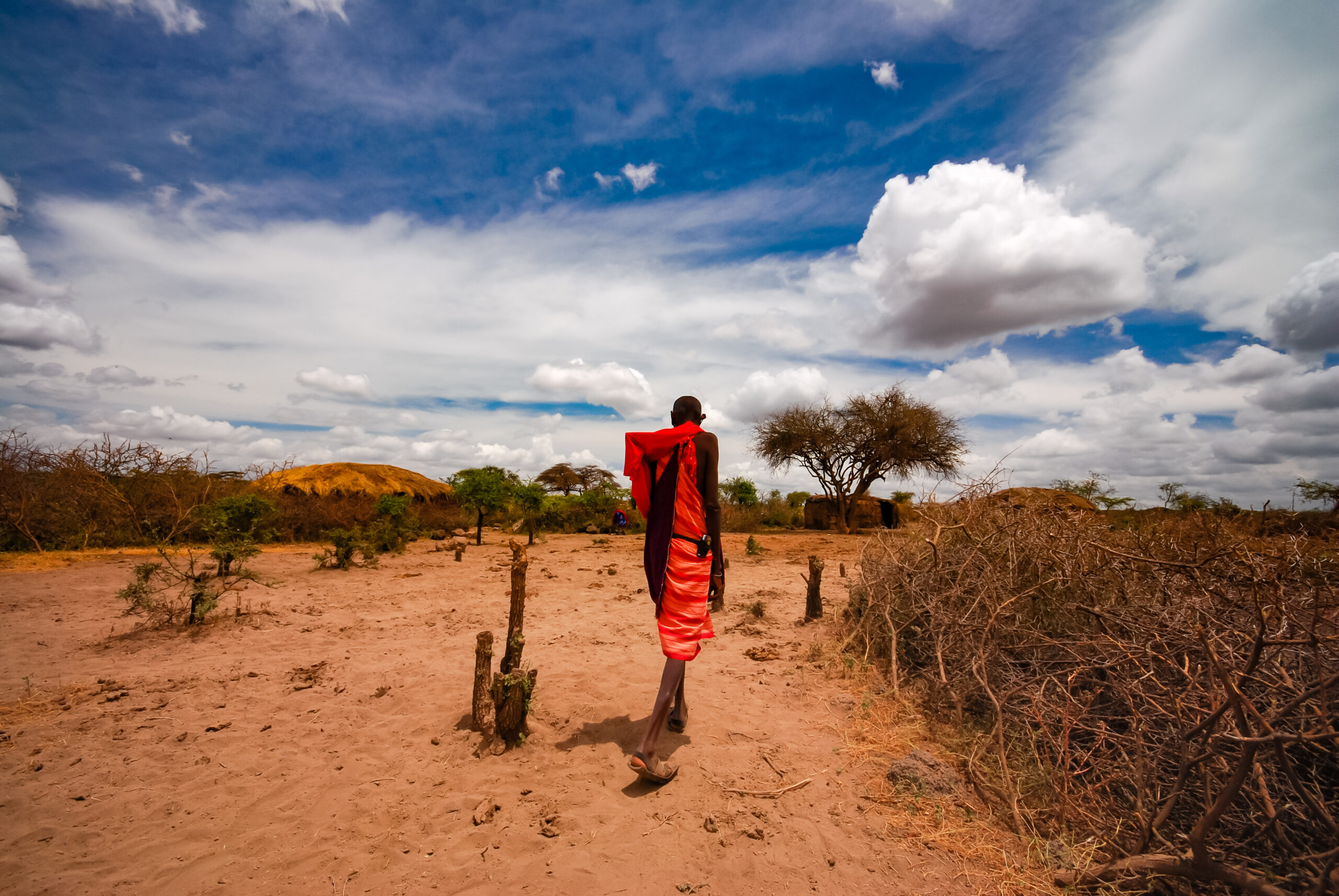 rear-view-man-standing-field-against-sky-masai-village